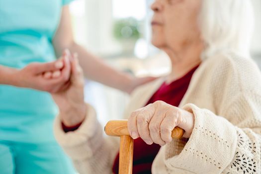 Close up view of senior woman hand in caregiver hands