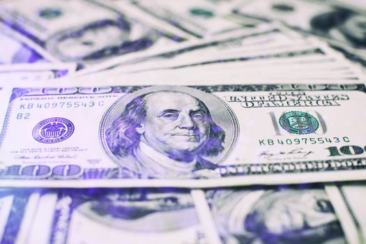 A stack of money. Heap of one hundred dollar bills on money background. Fake money. Shallow depth of field. Selective focus.