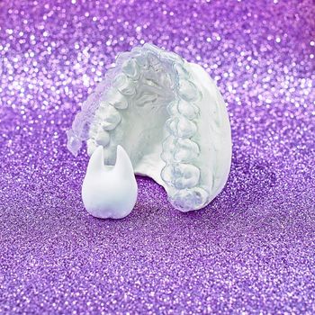 Orthodontic dental theme on  yellow background.Transparent invisible dental aligners or braces aplicable for an orthodontic dental treatment