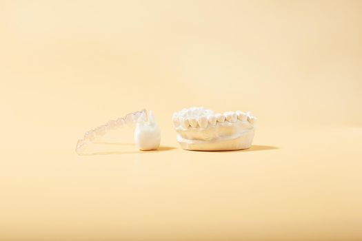 Orthodontic dental theme on  yellow background.Transparent invisible dental aligners or braces aplicable for an orthodontic dental treatment