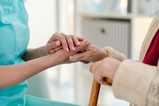 Close up view of senior woman hand in caregiver hands