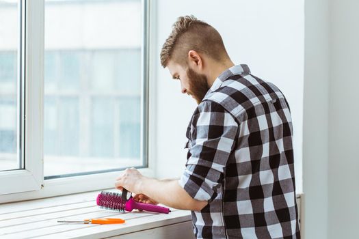 Fix and repair concept - Man working with a roll of adhesive aluminum foil tape.