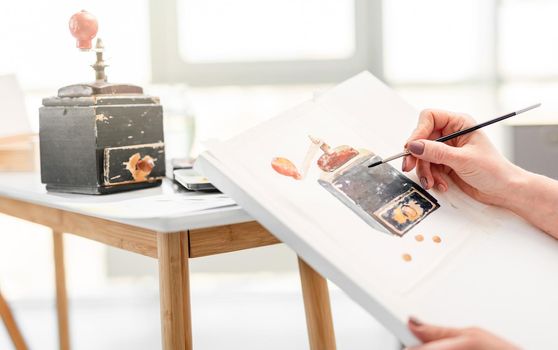 Drawing process from nature, Artist hand with paintbrush draws black music box using watercolor