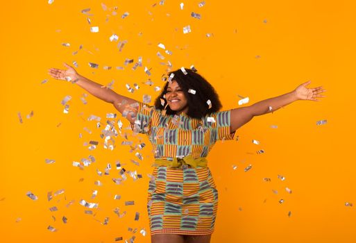 Celebrating happiness, young woman dancing with big smile throwing confetti