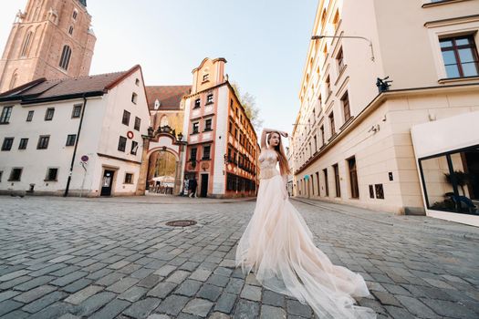 A bride in a wedding dress with long hair in the old town of Wroclaw. Wedding photo shoot in the center of an ancient city in Poland.Wroclaw, Poland.