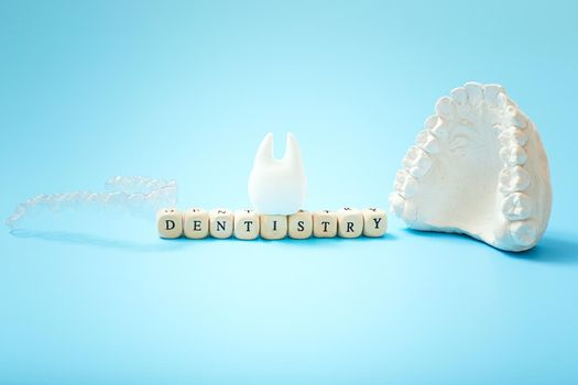 Dentist lettering for your advertisement on a blue background with invisible dental aligners or braces aplicable for an orthodontic dental treatment