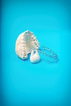 Orthodontic dental theme on blue background. Transparent invisible dental aligners or braces aplicable for an orthodontic dental treatment