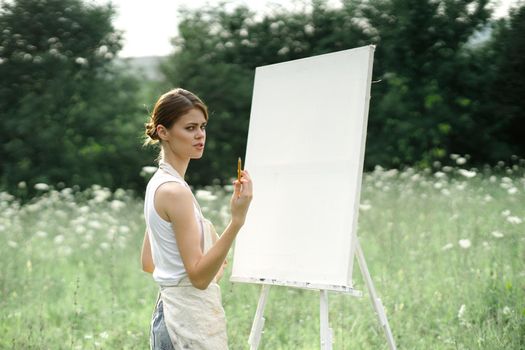 woman outdoors painting a picture creative art landscape. High quality photo