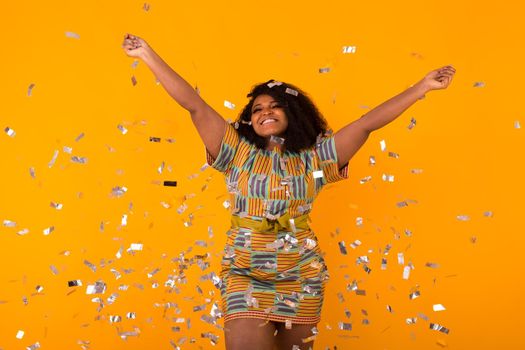 Celebrating happiness, young woman dancing with big smile throwing confetti