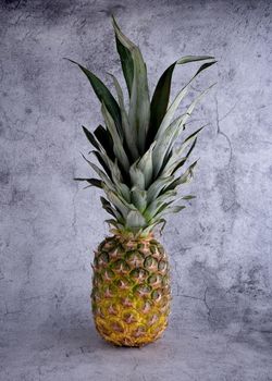 close up of ripe pineapple on a grey background