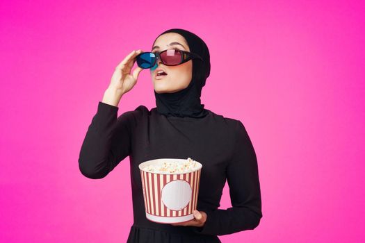 Muslim woman in 3D glasses popcorn entertainment movies isolated background. High quality photo
