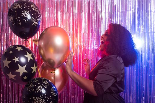 Portrait of a beautiful african american woman against twinkling background. Birthday party, nightclub and nightlife.