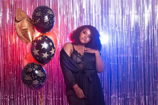 Portrait of a beautiful african american woman against twinkling background. Birthday party, nightclub and nightlife.