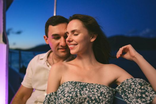 Portrait of happy loving couple on the yacht in the evening