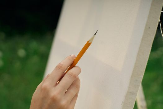 female hand with pencil easel drawing close up. High quality photo