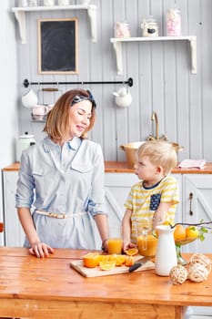 Mother and son are smiling while having a breakfast in kitchen. Bright morning in the kitchen. Healthy Breakfast cereals and fresh fruit