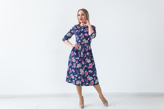 Fashionable young woman in beautiful dress posing at studio. Isolated over white.