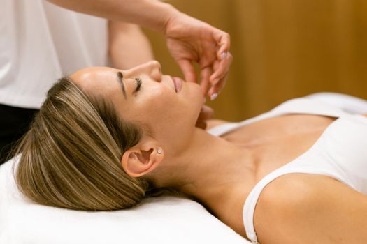 Middle-aged woman having a head massage in a beauty salon. Body care treatment in a beauty centre.