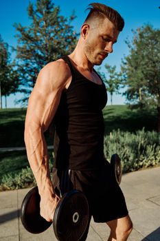 sporty man exercise fitness workout outdoors with dumbbells. High quality photo