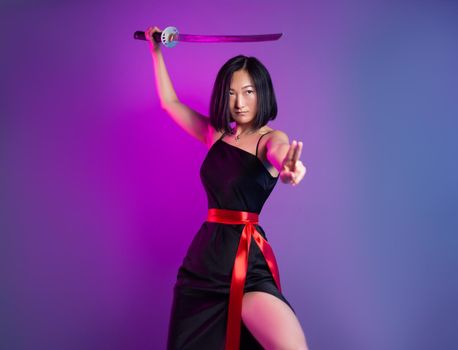 the slender Asian woman in a black dress with a katana in her hand image of a samurai on a neon background