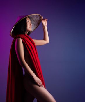 the asian woman in red cape and asian hat posing on bright neon background
