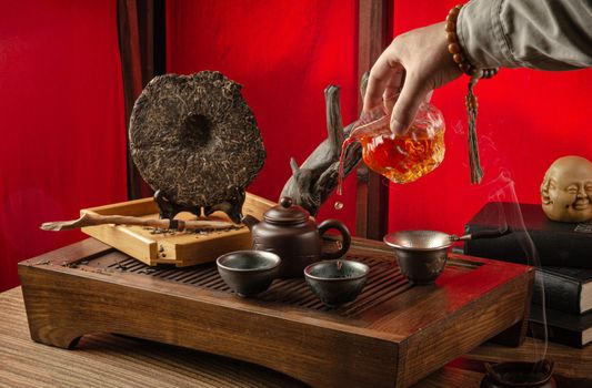 tea table with instruments teapots cups pancake and tea Shen Puer