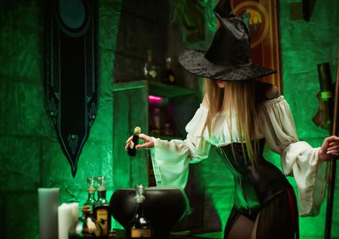 the women in a hat in the witch's room on Halloween