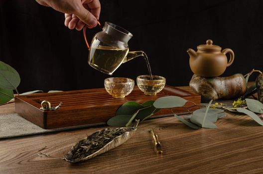 the tea table with instruments teapots cups pancake and tea Shen Puer