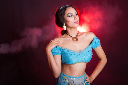 Portrait of a young woman in the image of an Eastern fairy Princess on dark background