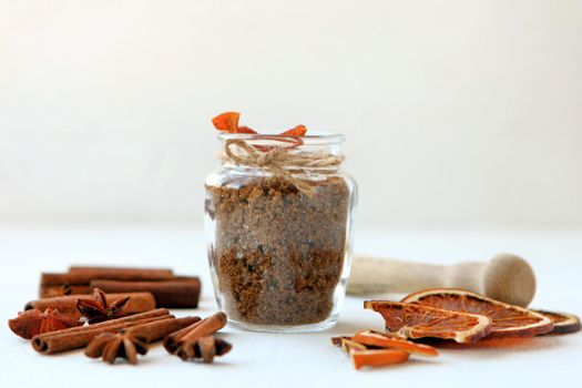 Cinnamon sticks, dried oranges and star anise with brown sugar bottle with shallow depth of field on white background. Baking ingredients for cooking