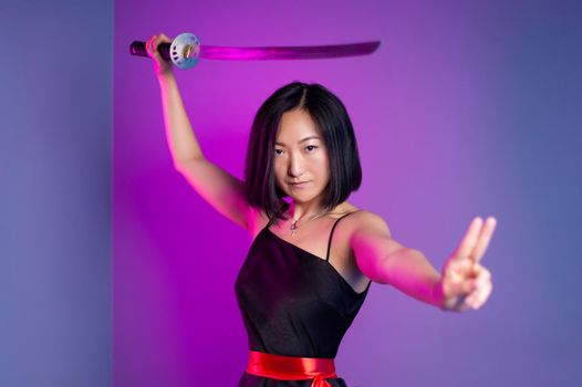 the slender Asian woman in a black dress with a katana in her hand image of a samurai on a neon background