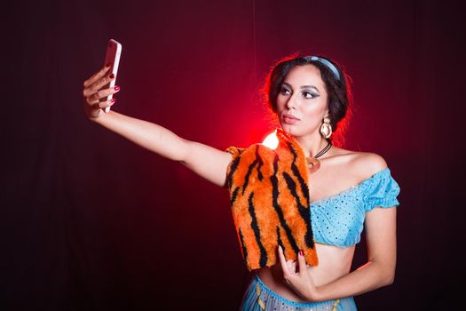 Girl doing selfie with tiger skin, crazy photos. Don't eco friendly lifestyle. Young woman takes pictures of herself in the phone. Life in social networks, narcissism, modern personality. Personality disorder