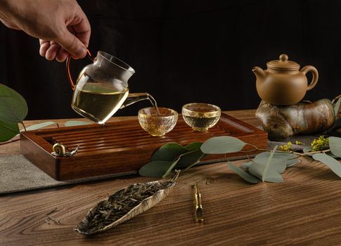 the tea table with instruments teapots cups pancake and tea Shen Puer