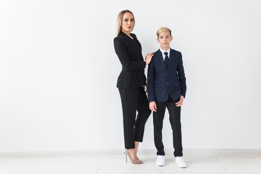 Teenager and single parent - Young mother and son standing together on white background