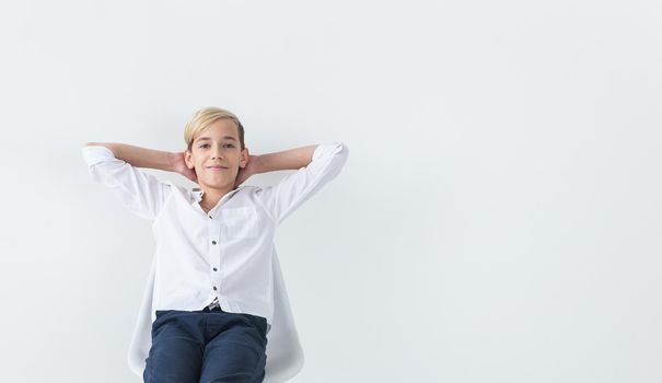 Solitude, loneliness and boredom concept - Bored teen student sitting in a school chair isolated on white