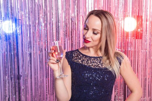 drinks, holidays and celebration concept - smiling woman in evening dress with glass of sparkling wine over shiny background