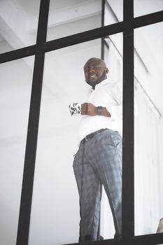 Successful Young Businessman. African American Man Before Trading On Stock Exchange Stay In His Downtown Office With Cup Of Tea. Concept Of Victory, Personal Growth. High quality photo