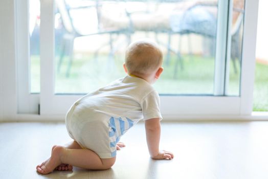 baby on his back crawling in the living room.