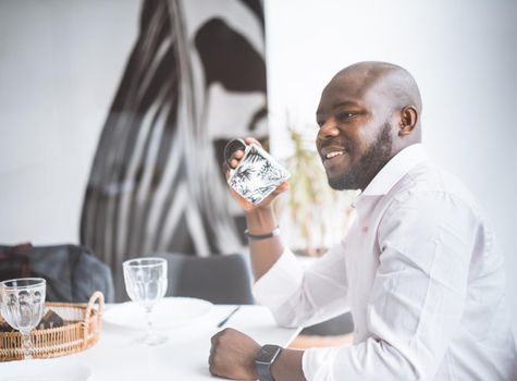 Successful Young Businessman. African American Man Smiling While Sitting At Breakfast In Luxury Apartment. Concept Of Rich Life, Personal Growth. High Quality Photo