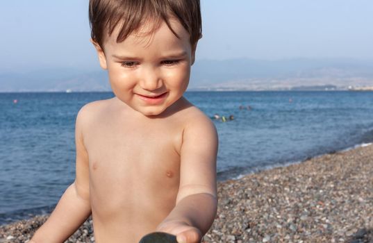 Healthy lifestyle. Little boy resting and having fun on a rocky beach on the Mediterranean coast