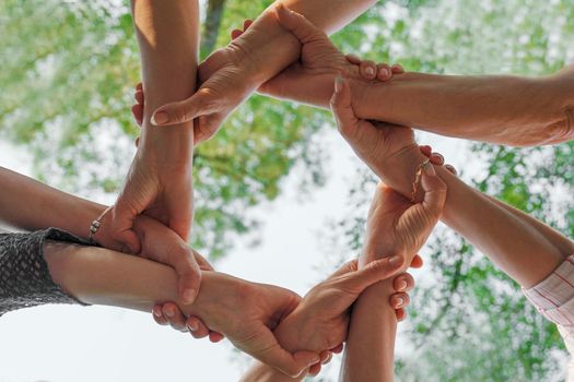 Team stacks hands in a workshop for teambuilding and teambuilding.