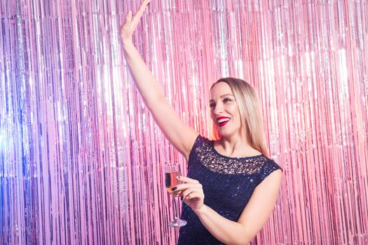 drinks, holidays and celebration concept - smiling woman in evening dress with glass of sparkling wine over shiny background