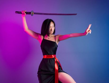 the slender Asian woman in a black dress with a katana in her hand image of a samurai on a neon background