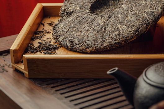 tea table with instruments teapots cups pancake and tea Shen Puer