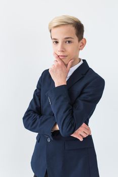 Portrait of stylish school boy teenager in white shirt and jacket against white background with copy space