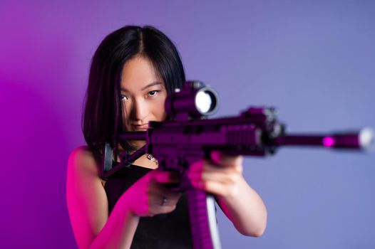 the asian woman with a machine gun aims for shooting