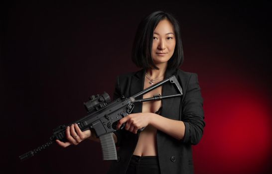 the asian woman in a jacket with an automatic rifle in her hands mafia fighter