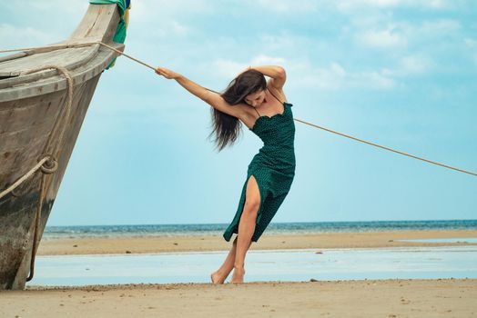 the photo of a charming brunette long-haired woman on the ocean. Fashion and glam concept. Copy space