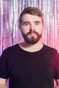 Party, carnival, holidays and emotional concept - Sad man against shiny background