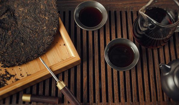 tea table with instruments teapots cups pancake and tea Shen Puer